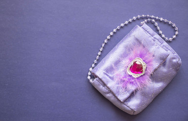 women's purple handbag on a purple background, copy space