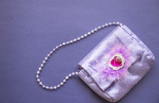 women's purple handbag on a purple background, copy space