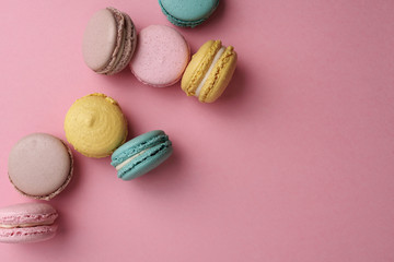 Pastel french macaroons on pink background. Flat lay style, place for text