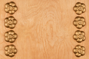Frame of golden decorative decorations lying on a tree.
