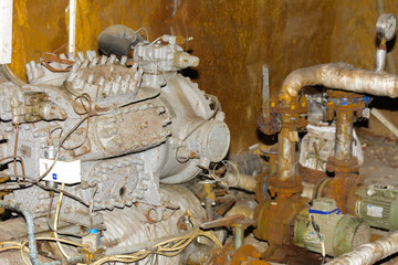 Old dismantled and rusty heat-exchange equipment at an abandoned and destroyed factory against a backdrop of chaos. Destruction and vandalism. Ukraine.