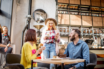 Young friends dressed casually have fun spending time in the beautiful cafe