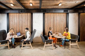 Friends dressed casually talking in the cafe on the wooden wall background