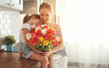 happy mother's day! child daughter   gives mother a bouquet of flowers to tulips - Powered by Adobe