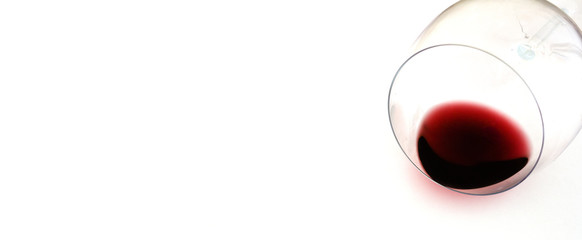 ein ausgegossenes weinglas auf einem weissen hintergrund