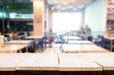 Selected focus empty brown wooden table and Coffee shop or restaurant blur background with bokeh image. for your photomontage or product display.