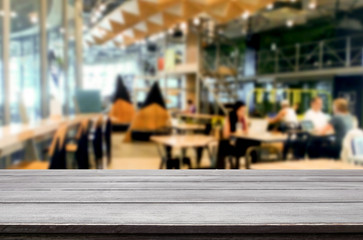 Selected focus empty brown wooden table and Coffee shop or restaurant blur background with bokeh image. for your photomontage or product display.