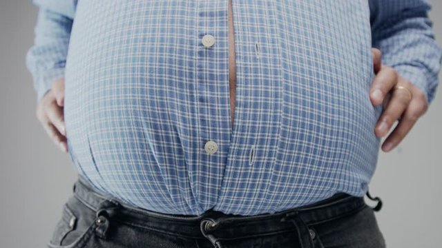Overweight man in shrt is small to him with huge belly and open buttons