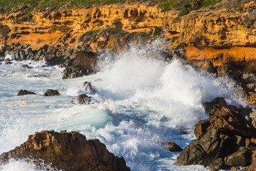 Big waves crashing against Alghero rocky shoreline