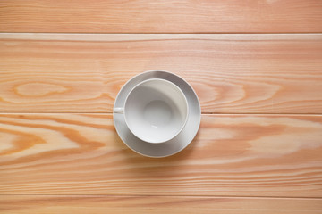 empty white cups with fried coffee beans on a wooden surface