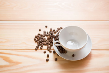 empty white cups with fried coffee beans on a wooden surface
