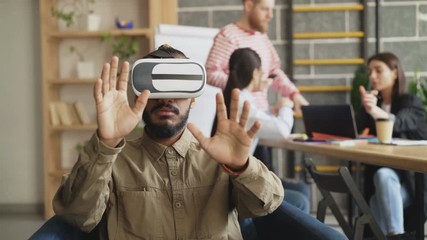 African american man testing VR simulator in game development office. Start-up creative team discussing future virtual reality technology project - Powered by Adobe