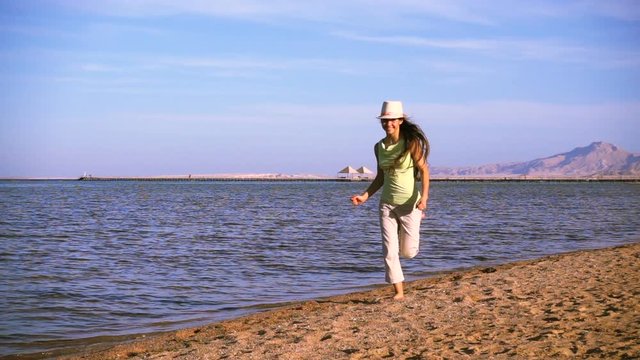 Young girl running at the beach of Red sea, slow motion