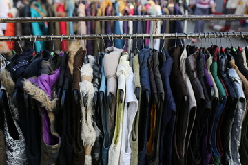 Variety of colored winter and autumn clothes on metal hangers in the wardrobe of a cinema on back stage, theater or exhibition. Top view of a large number of different clothes