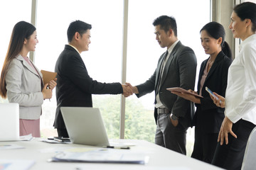 Business people shaking hands, finishing up a meeting in the office.