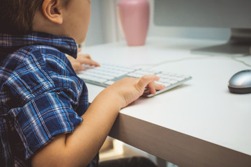 Obraz na płótnie Canvas Close up of kid typing on computer keyboard.