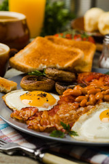 Full English breakfast, with sausage, mushrooms, beans and a fried egg.