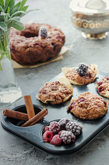 Obraz na płótnie Canvas Chocolate homemade muffins with rapsberry, blackberry on grey background, still life composition