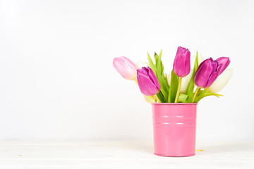 Purple tulips in pink bucket