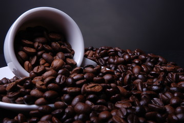 Kaffebohnen ergießen sich aus der Tasse