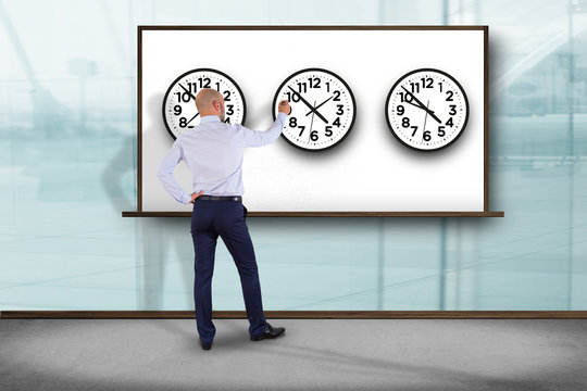 Businessman in front of a wallwith clocks of different country - Jetlag concept