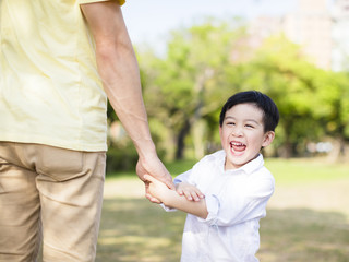 father holds the hand of little boy