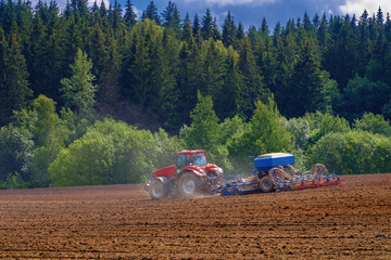 Tractor with cultivator handles field before planting. Preparing land for sowing at spring, farmer in tractor