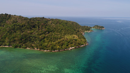 Aerial drone view of beautiful island coastline with rocks and transparent sea water around in sunny summer day