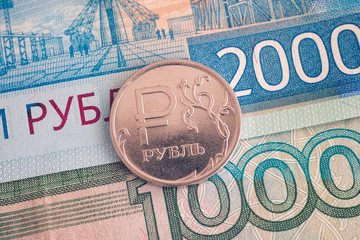 One and Two thousand ruble banknotes and one-ruble coin on it