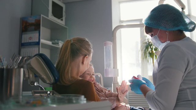 Young woman and her daughter at the consultation with the dentist