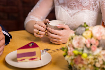 Obraz na płótnie Canvas girl drinks coffee with fruit cakes at a cafe