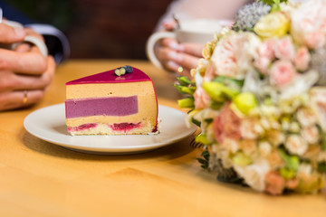 couple drinks coffee with fruit cakes at a cafe