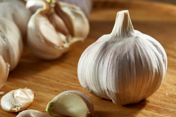 Garlic close up on wooden plate on rustic background, shallow depth of field, selective focus, macro