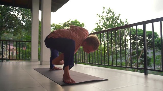 Man practice revolved side angle yoga pose at balcony sunrise rapid slow motion