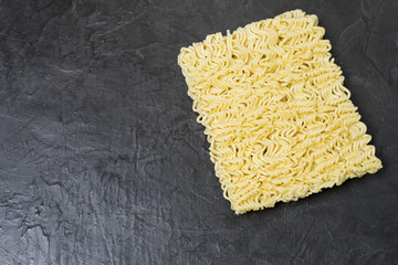 Egg noodles on a black background. Place for your text.