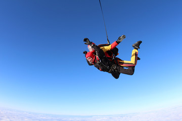 Skydiving. Tandem jump in the blue sky.