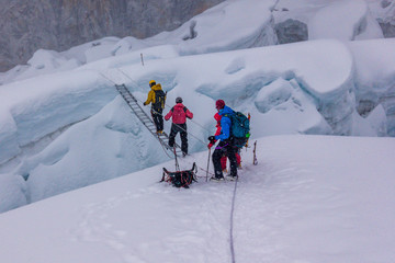 Climbers crossing a crevasse over a ladder, Island Peak, Everest Region, Nepal