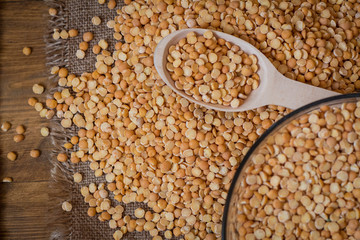 Peas on a wood background and burlap top view