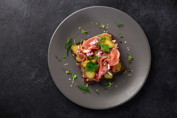 open sanwiches with dark rye bread, smoked meat, pickled cucumber  and red onion