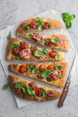 italian bread focaccia with prosciutto,tomatoes, basil and sea salt