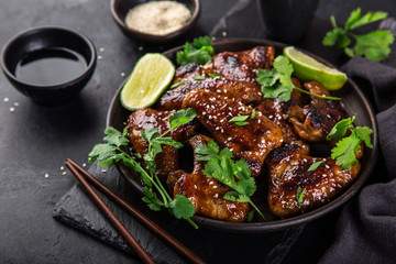 chicken wings roasted with teriyaki sauce, served with lime, cilantro and sesame seeds,