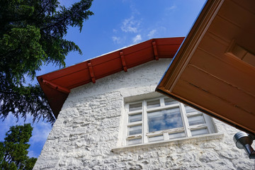 A white building with a red roof, house or cottage.