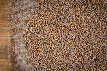 Buckwheat. Buckwheat on wood background and burlap top view