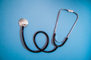 Stethoscope on a blue monophonic background, used in medicine
