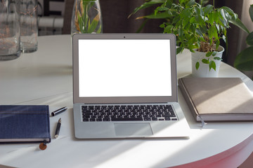  Workplace with laptop on white table and next to plants