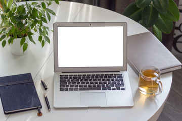  Workplace with laptop on white table and next to plants