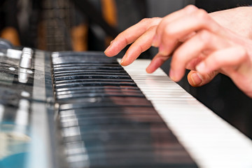 Hands of a pianist close-up. Plays on the synthesizer. Selective focus