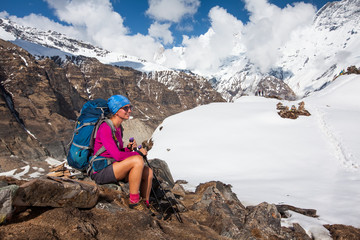Fototapeta premium Woman rests in the mountains on the way to Annapurna base camp, Nepal