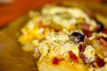 homemade pizza with peppers, plums, ham, sausage, cheese and spices, closeup