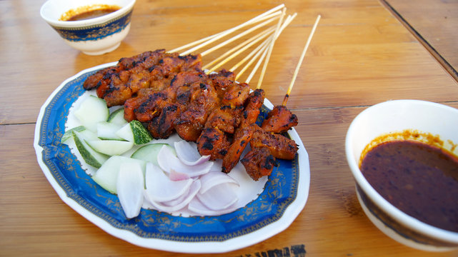 SINGAPORE - APR 3rd, 2015: Delicious tasty skewers of chicken cook over hot coals in Singapore's Satay Street food market